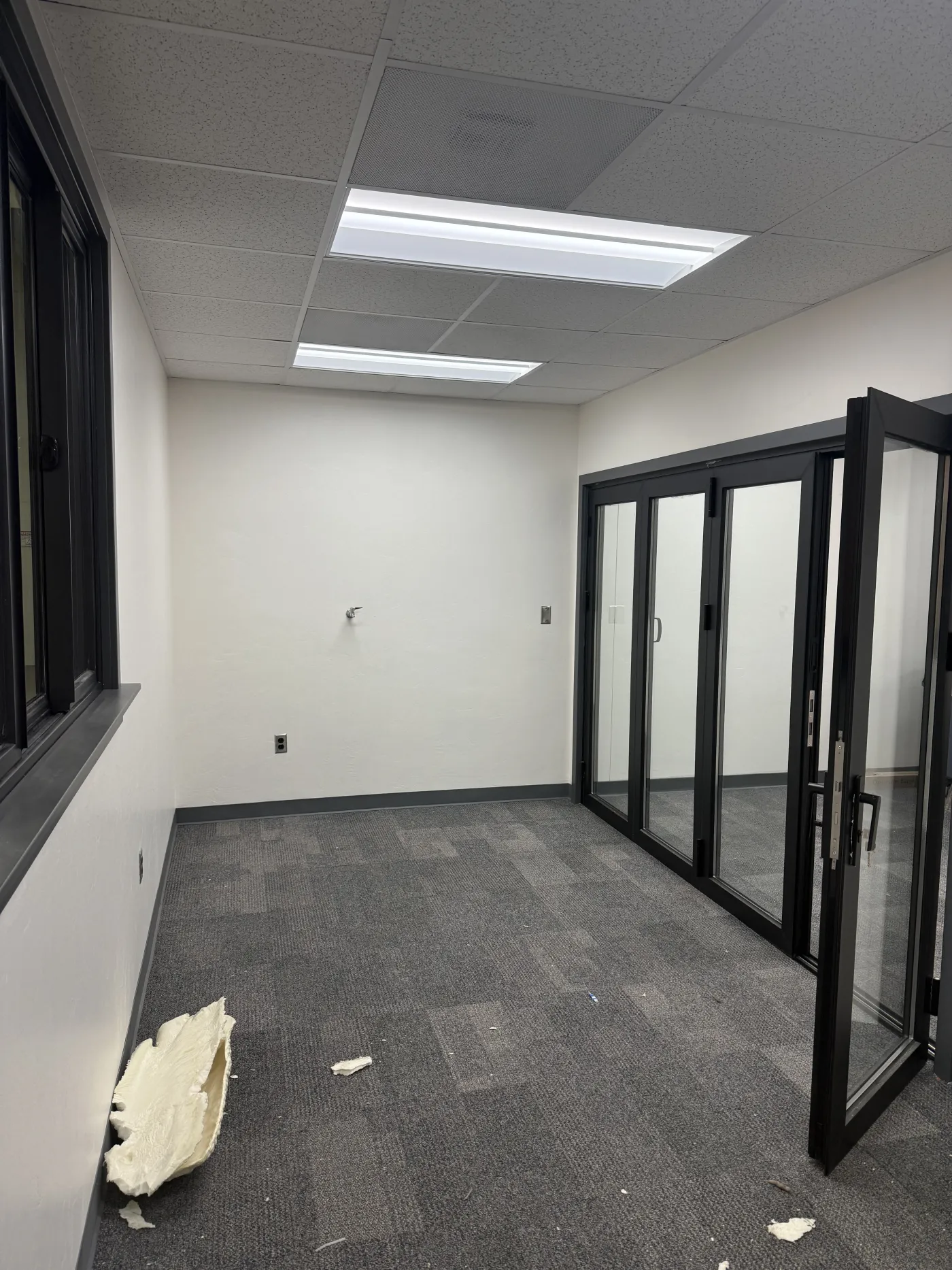 A chamber during fit-out — folding partition to the right, sliding observation window to the left.